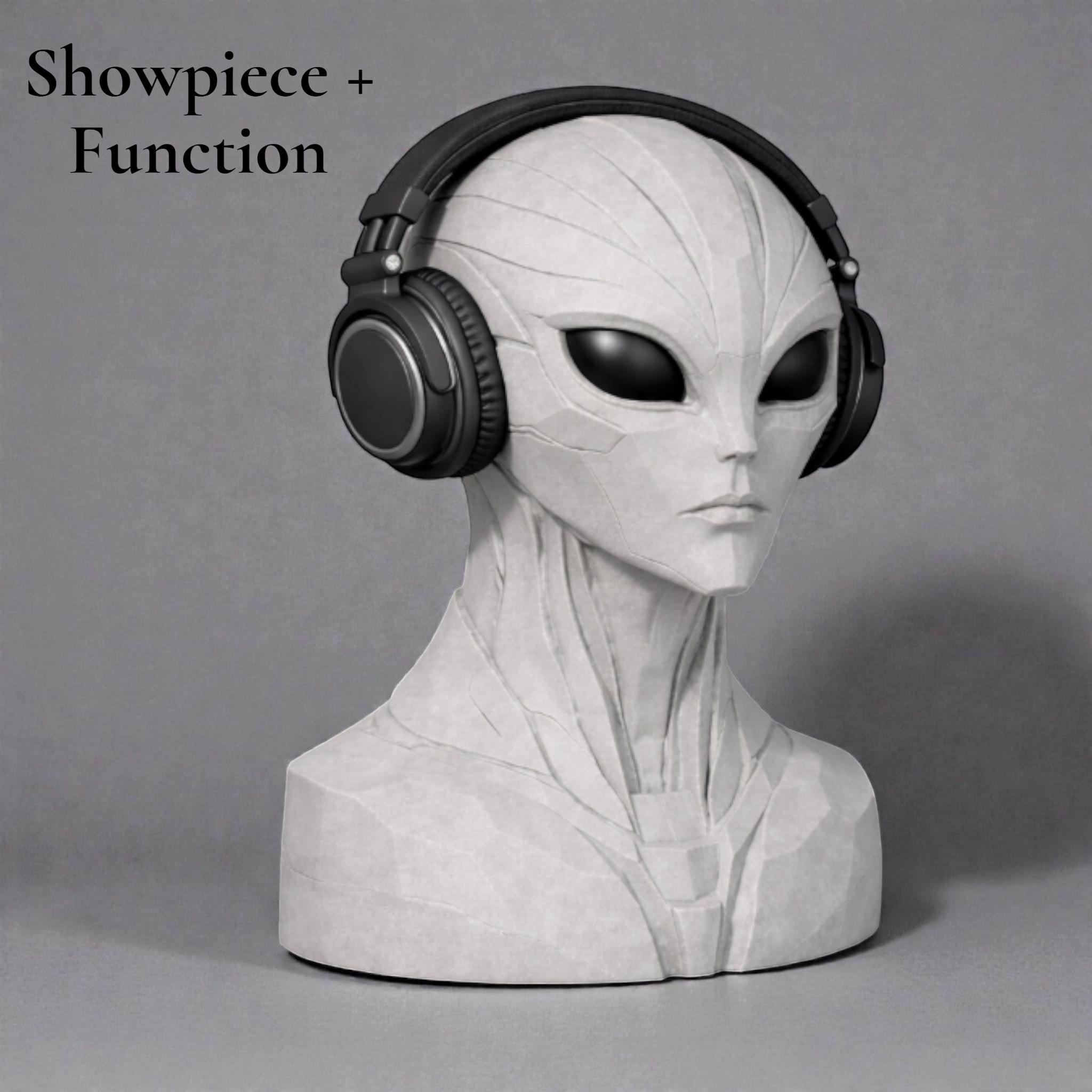 Happy3dWorld alien bust headphone stand in matte grey, holding black over-ear headphones on a neutral background.