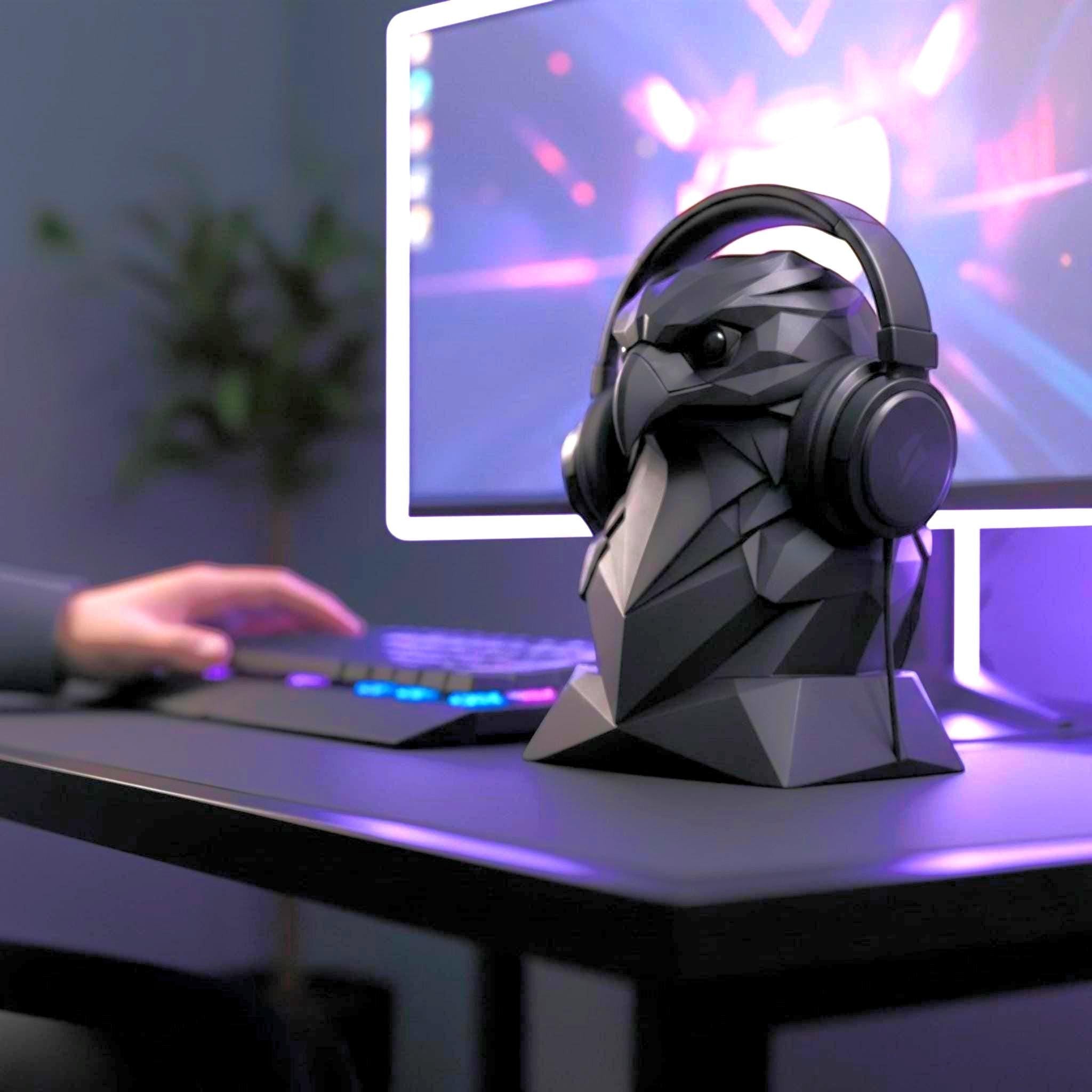 Happy3dWorld black geometric eagle headphone stand on a gaming desk with a headset and computer monitor in the background