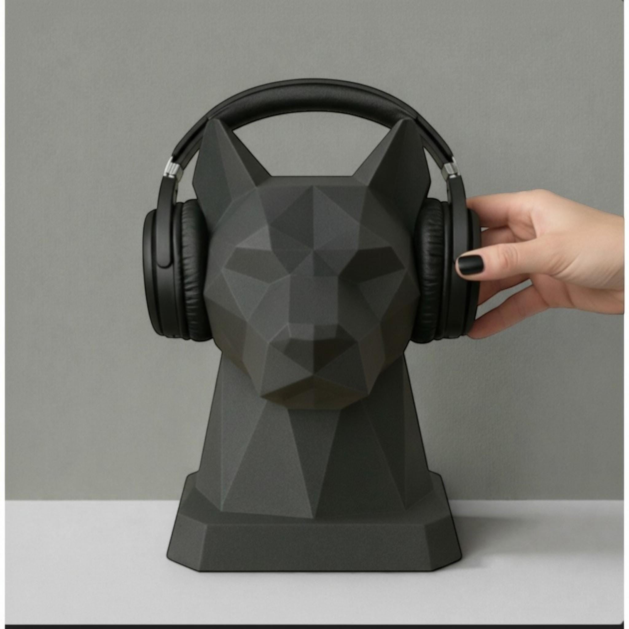 Happy3dWorld black low-poly geometric dog headphone stand holding black over-ear headphones on a desk