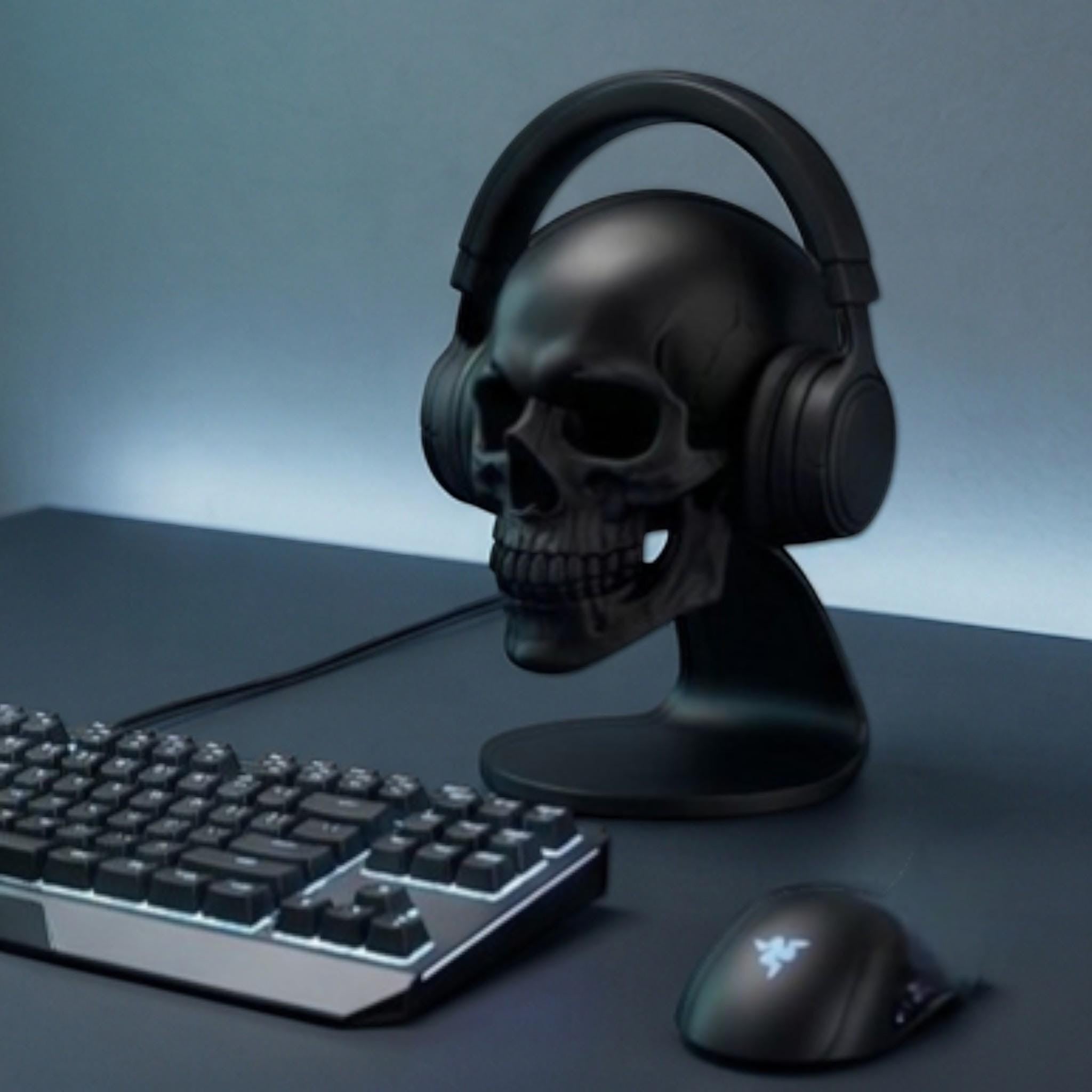 Happy3dWorld matte black anatomical skull headset stand holding over-ear headphones on a dark gaming desk setup