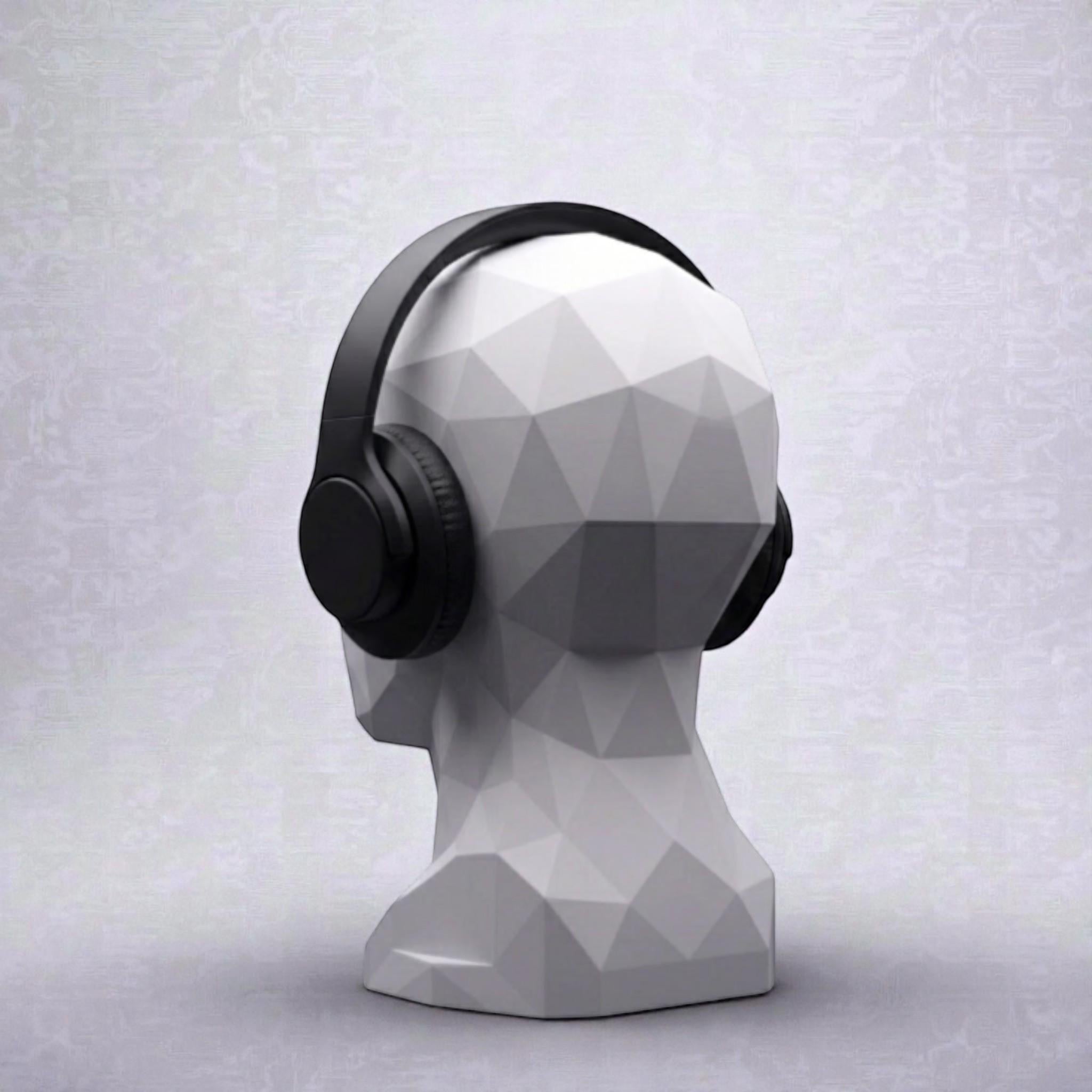 Happy3dWorld minimalist white geometric human bust headphone stand displaying black over-ear headphones on a desk.