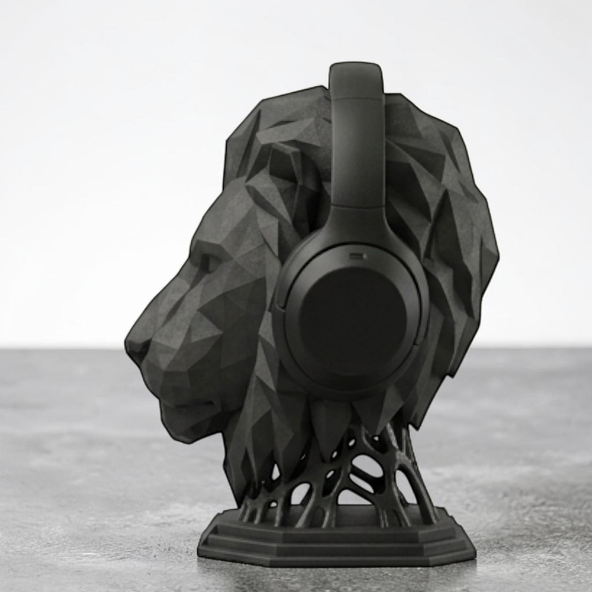 Happy3dWorld matte black geometric lion head headphone stand with a modern polygon design on a desk.