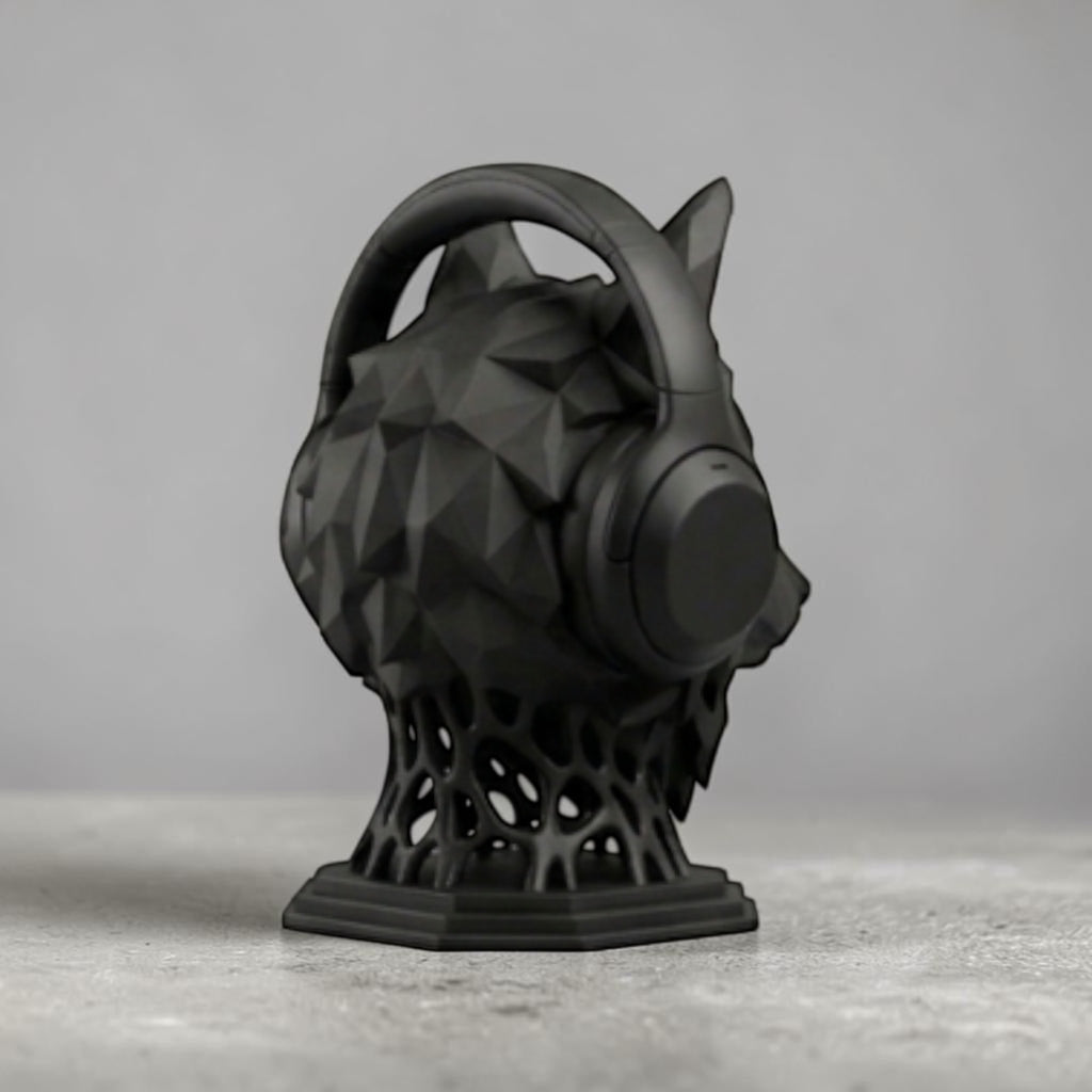 Happy3dWorld matte black geometric wolf head headphone stand with a low-poly design on a grey desk surface.