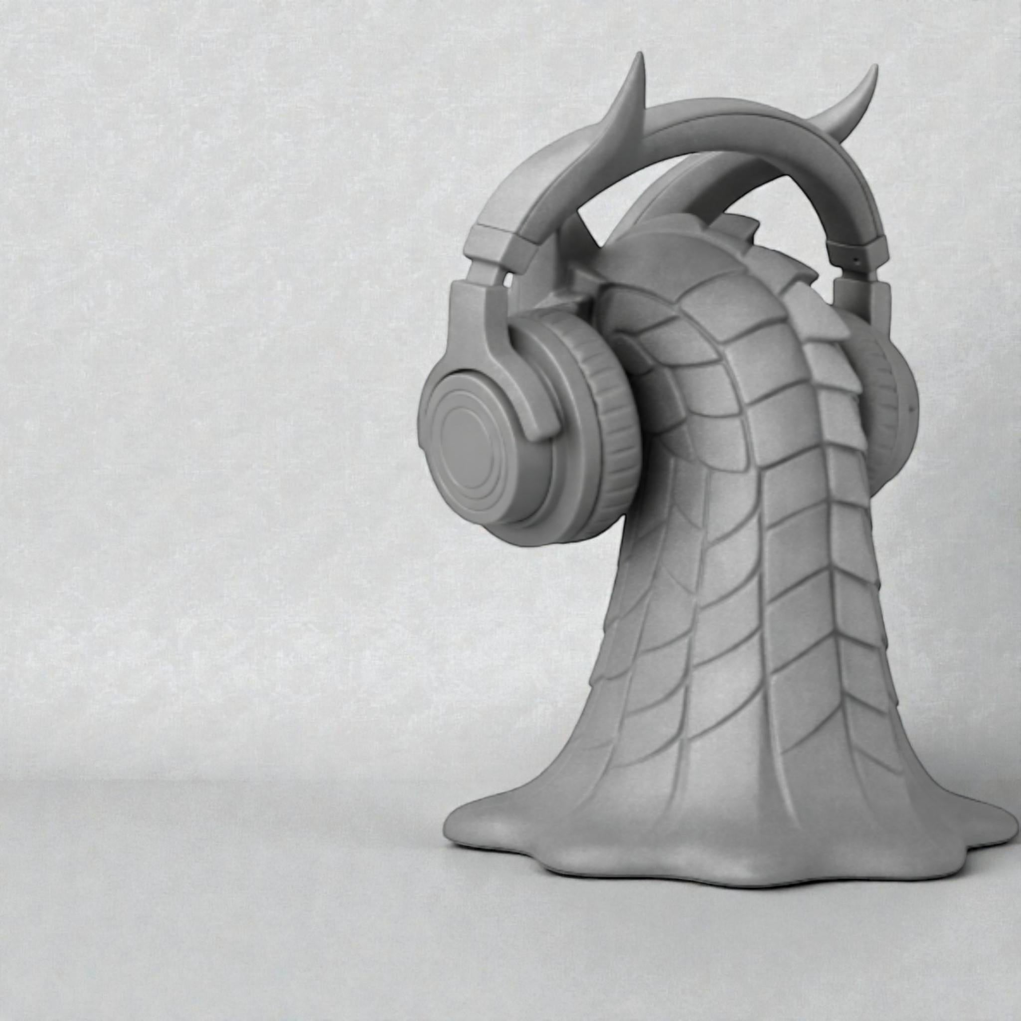 Happy3dWorld gray 3D printed dragon head headphone stand with intricate scales and horns holding over-ear headphones.