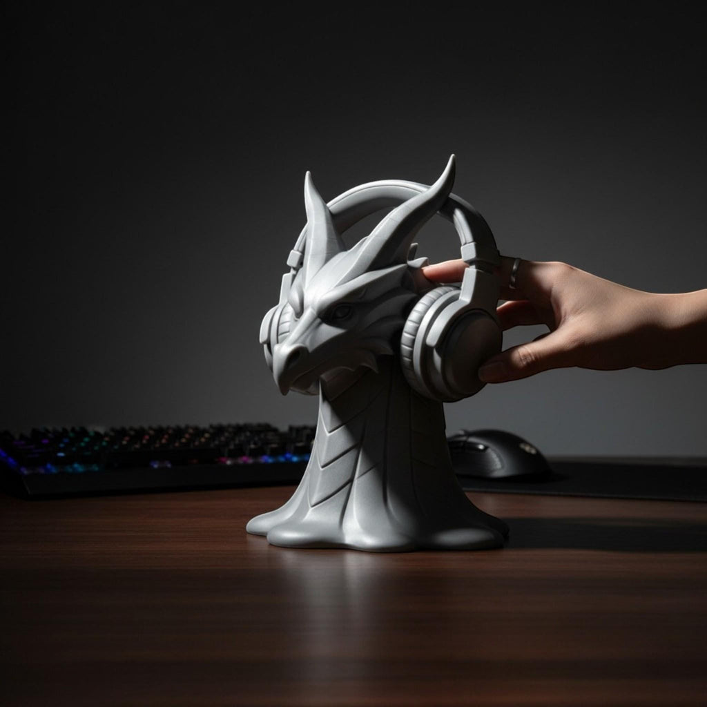 Happy3dWorld gray dragon head headphone stand holding over-ear headset on a wooden desk in a dark gaming setup.