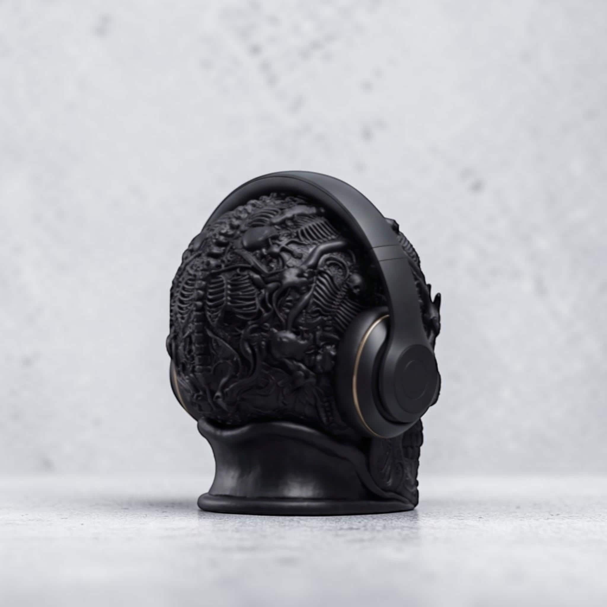 Happy3dWorld matte black gothic skull headphone stand with intricate baroque textures holding over-ear gaming headphones.