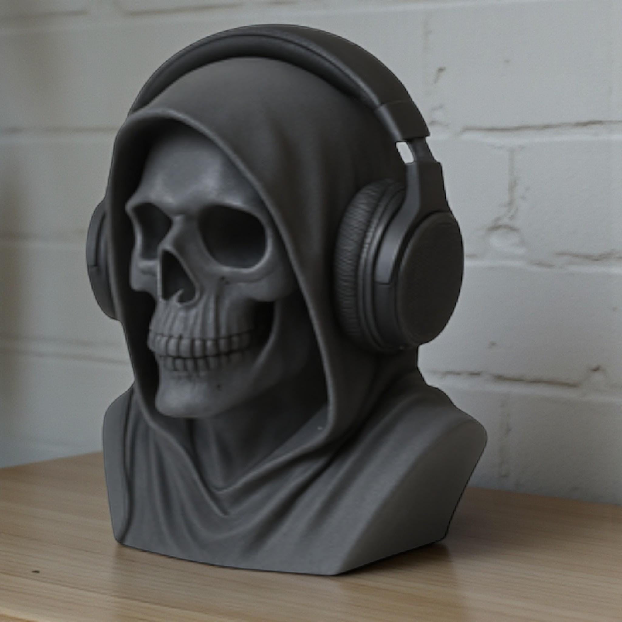 Happy3dWorld matte black death angel skull headphone stand with a hooded design on a wooden desk