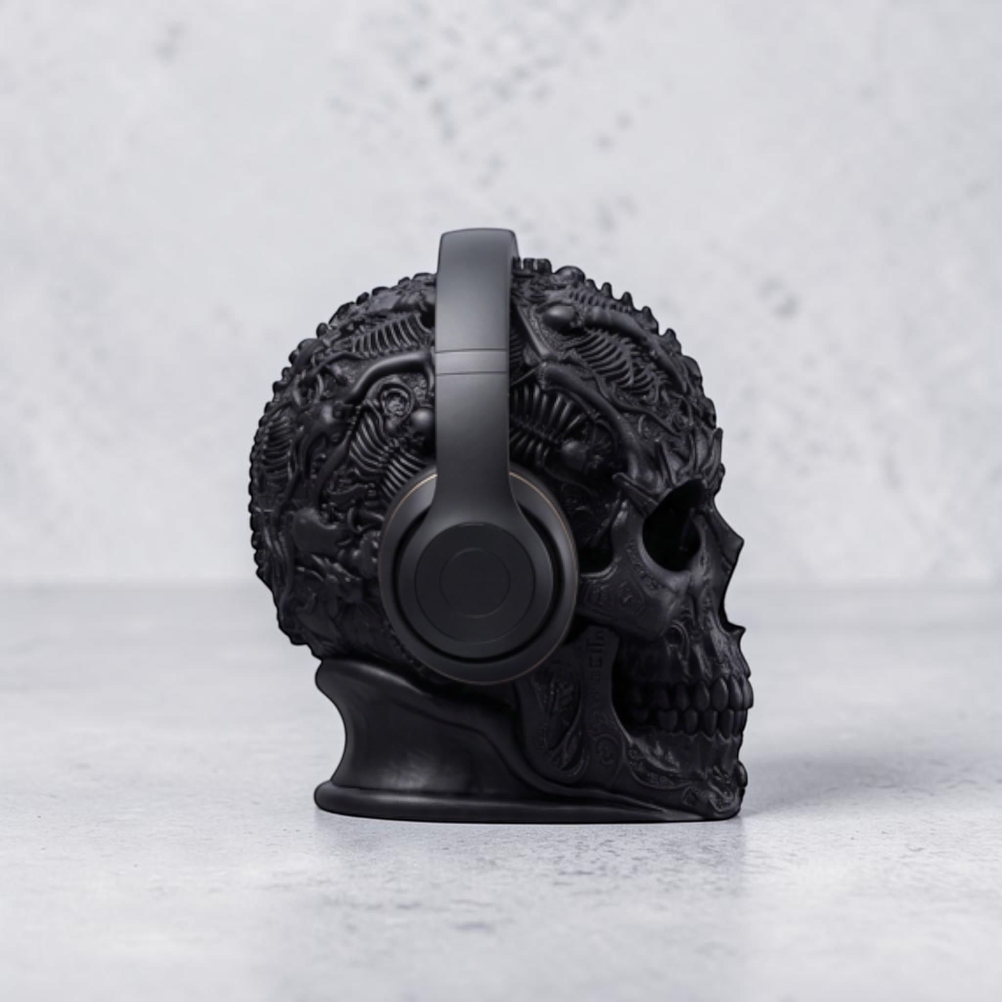 Happy3dWorld matte black gothic skull headphone stand with intricate baroque textures holding over-ear headphones.
