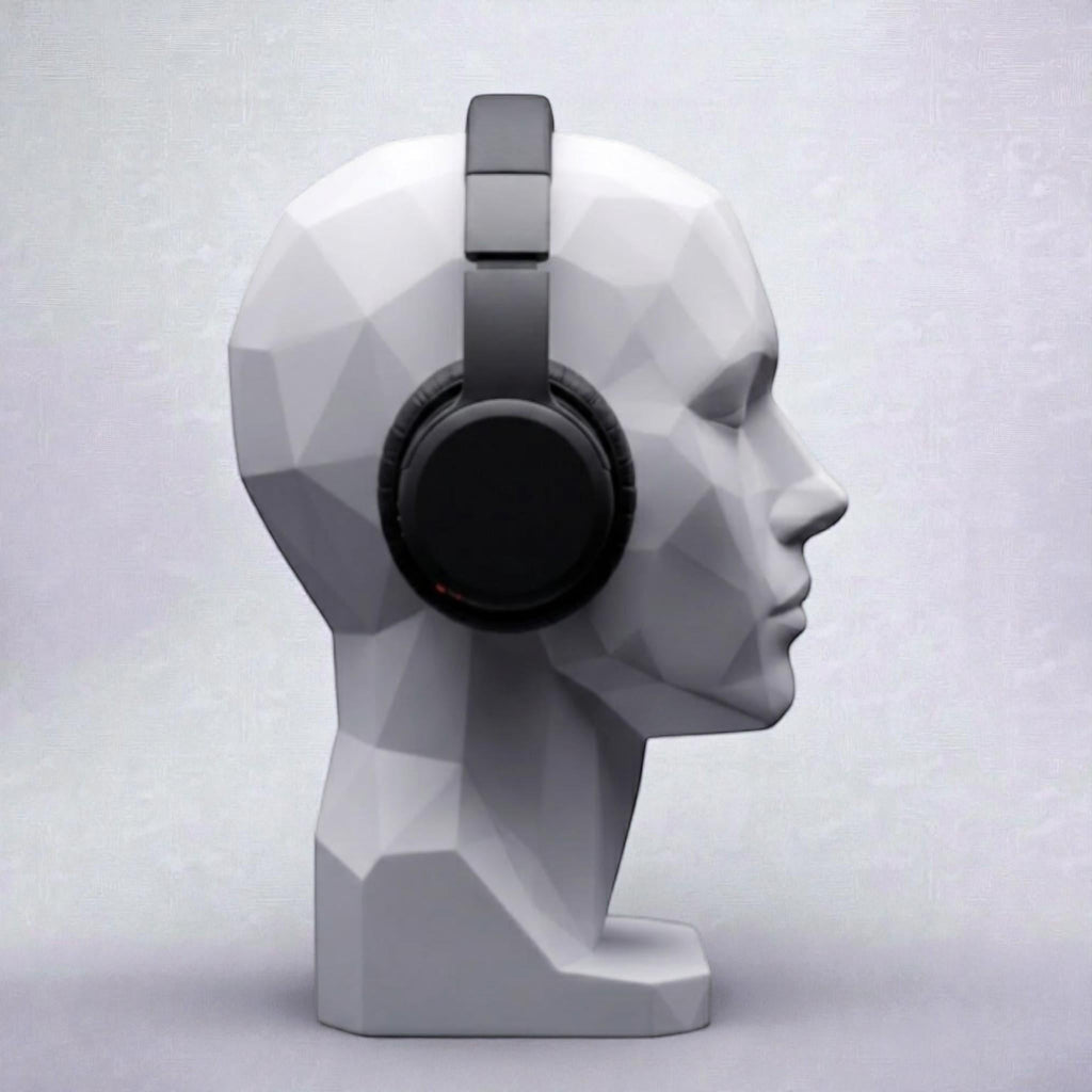 Happy3dWorld white geometric human bust headphone stand displaying black over-ear headphones on a minimalist desk.