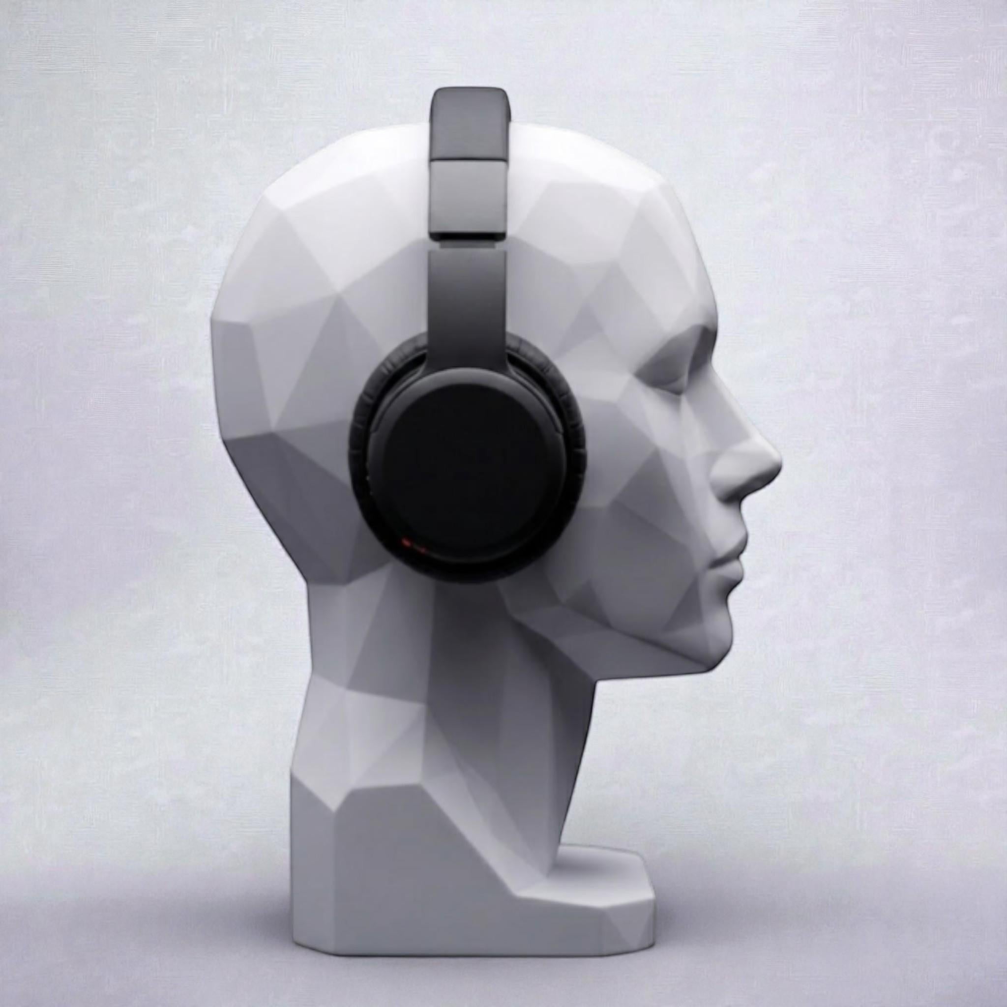 Happy3dWorld white geometric human bust headphone stand displaying black over-ear headphones on a minimalist desk.
